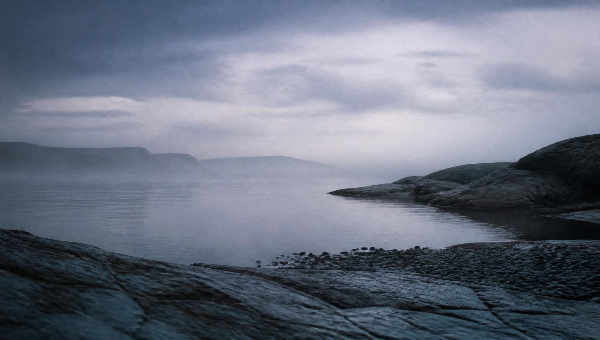 A quiet Nordic shoreline at dusk, still water meeting dark stone